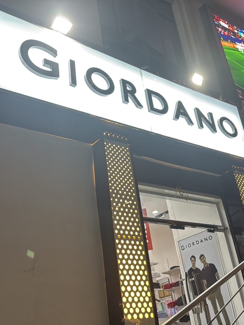 Front of the Giordano store at Somnet Building, Waaberi – lit GIORDANO sign above the entrance at night